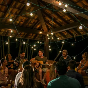 Gruppe von Leuten, die mit der Gitarre zusammensitzt und feiert.