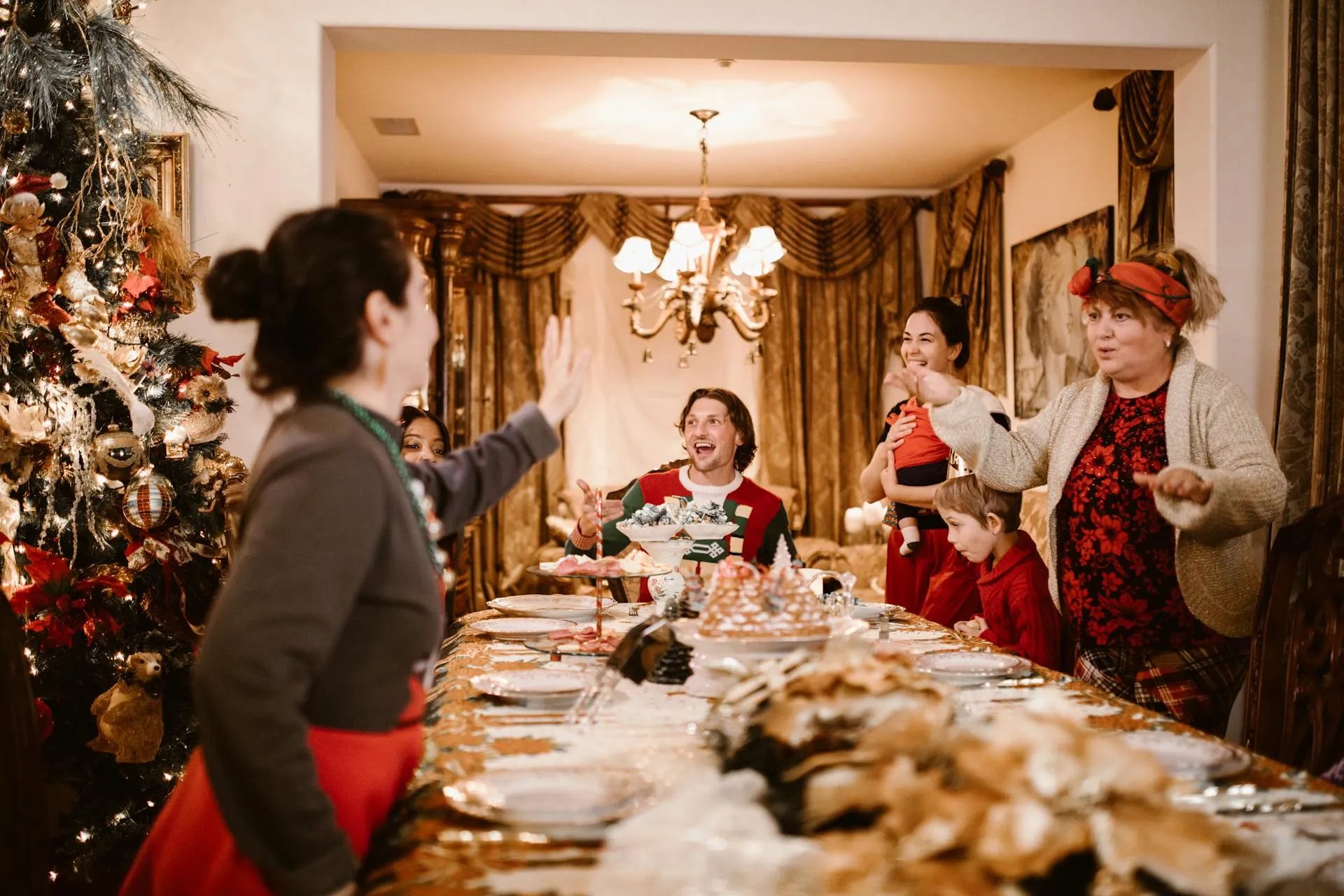 Familie beim Weihnachtsfest tanzt um den Tisch.